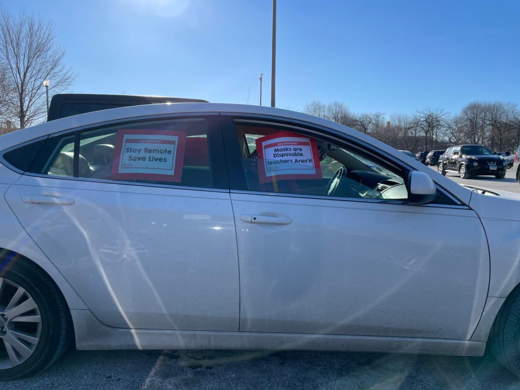 A side-view of a sedan with a sign in each window